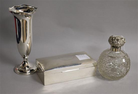 A late Victorian silver mounted scent bottle, a silver spill vase and a silver cigarette box.